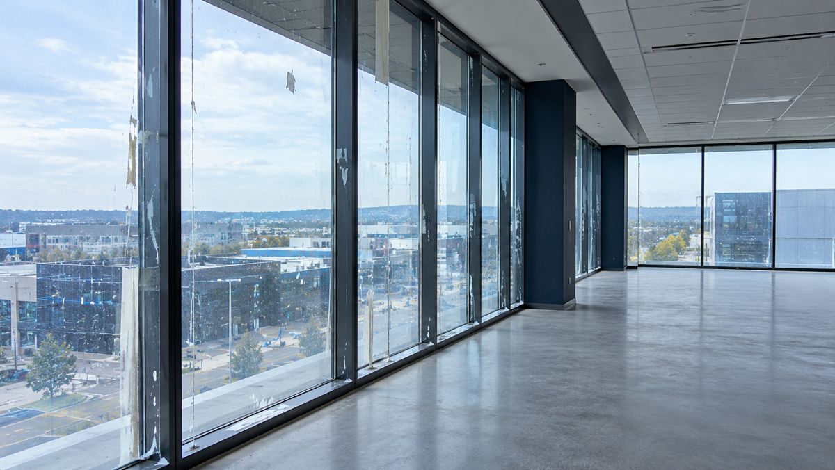 Empty new office floor with paint marks and tape residue on the windows